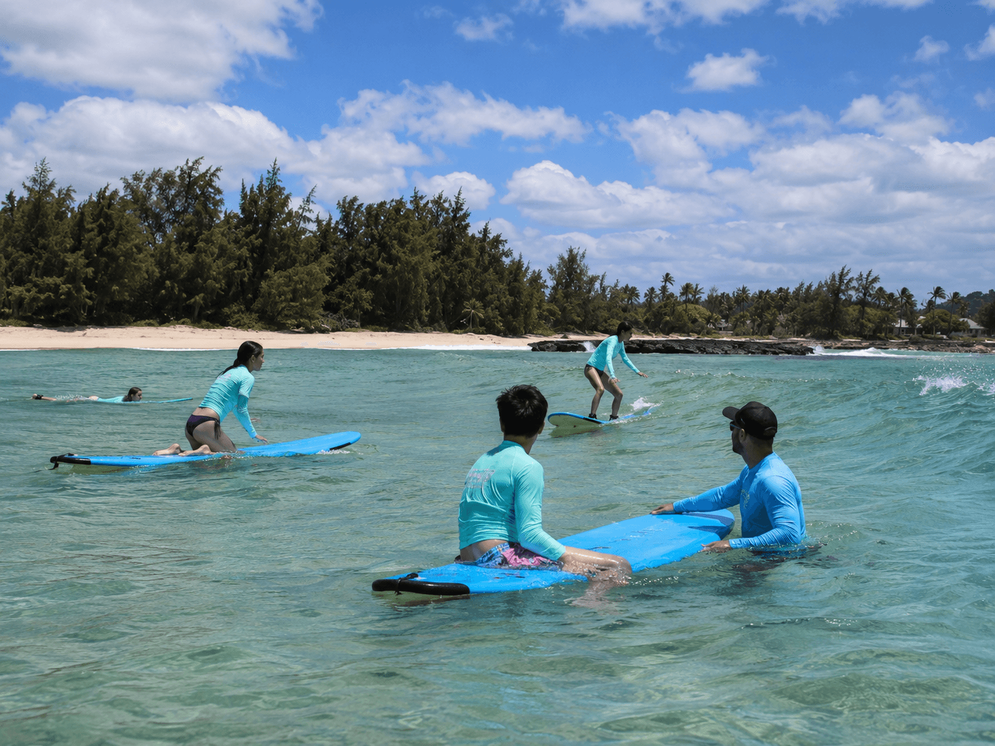 Beginner surfers taking a guided surf lesson at Turtle Bay